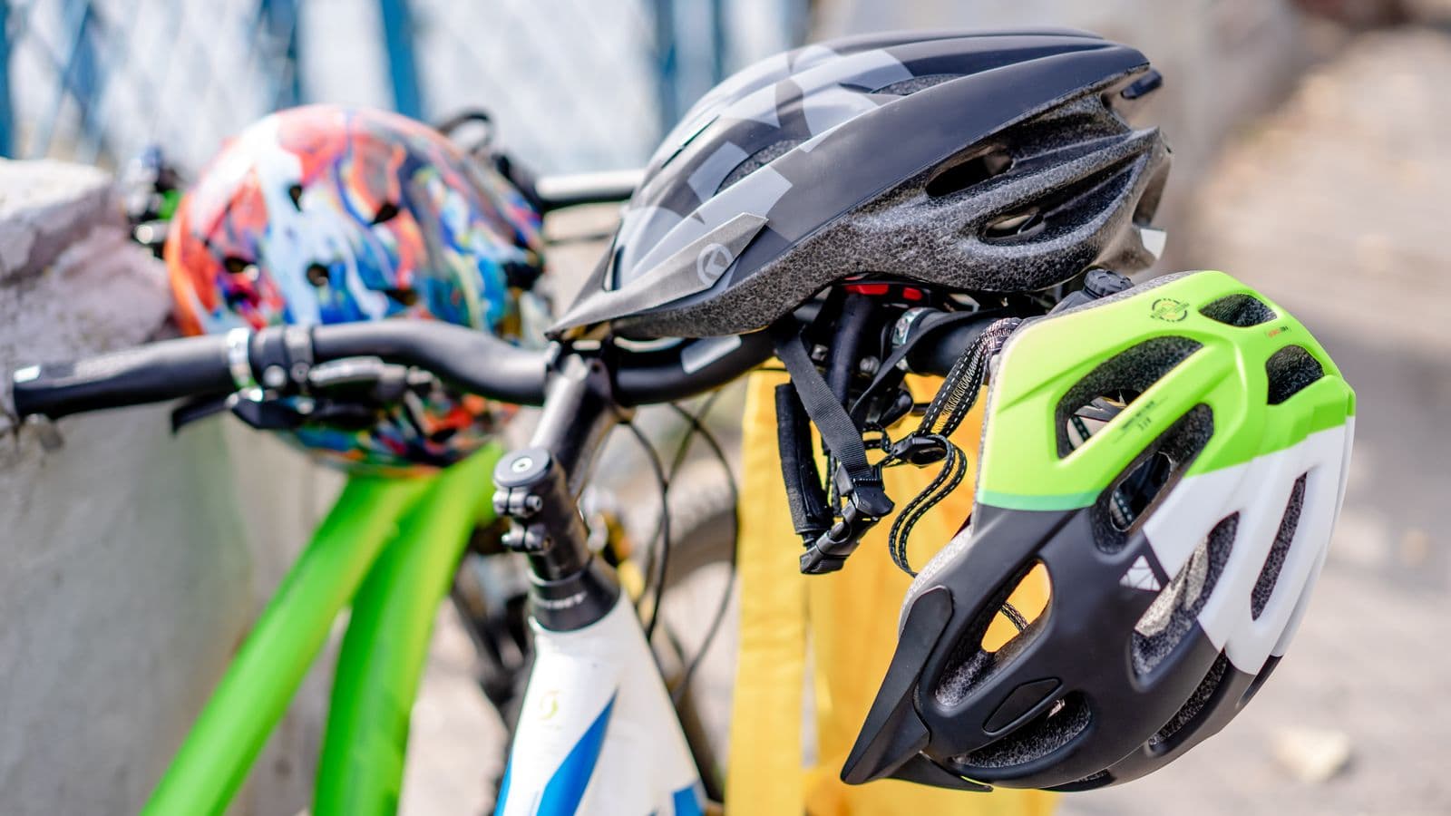 Casques de vélo colorés posés sur des guidons