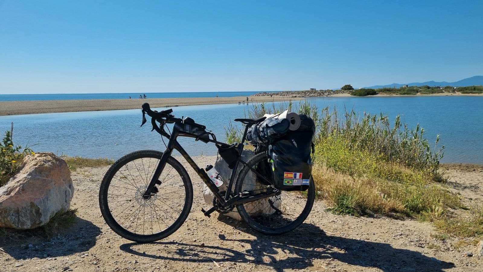 Vélo équipé de sacoches en bord de mer