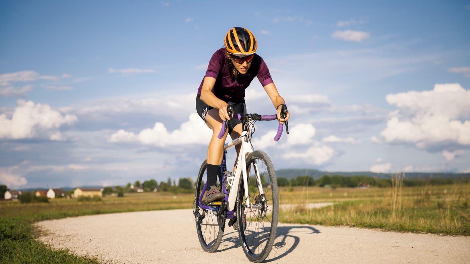 Cycliste en position de pédalage sur une piste gravillonnée