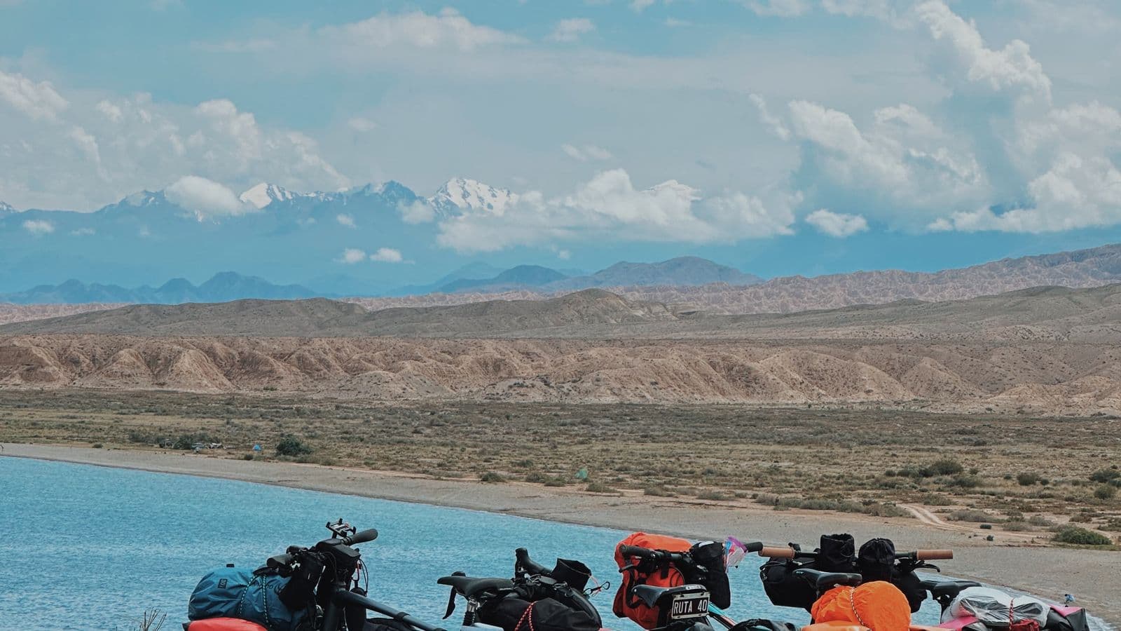 Vélos posés au bord d'un lac, montagnes en arrière-plan