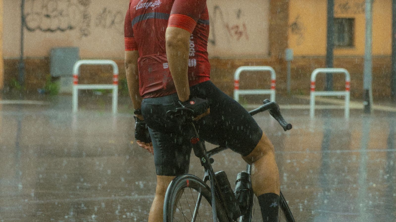 Cycliste à l'arrêt sur une chaussée détrempée en ville