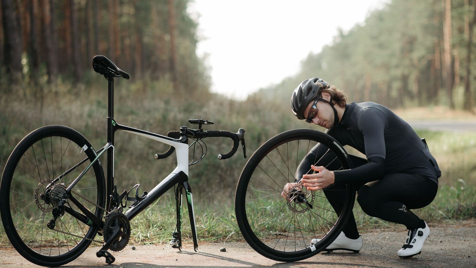 Cycliste intervenant sur une roue avant au bord d'un chemin