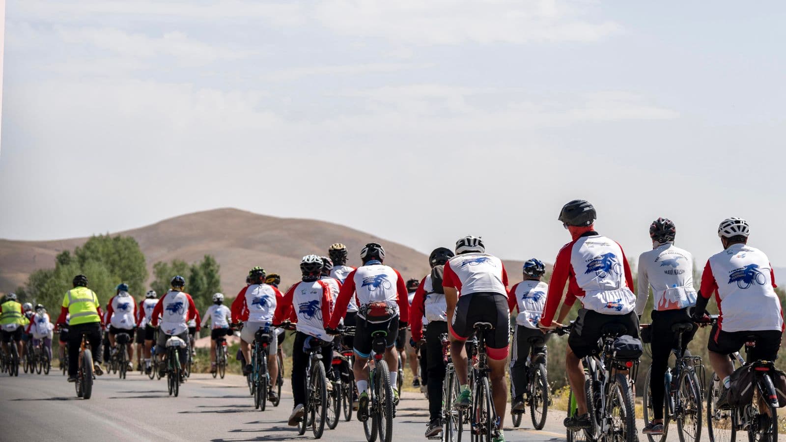 Cyclistes en peloton sur une route ouverte, positions de conduite variées